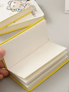 Close-up detail of a mini portable pocket notebook showing blank white pages and yellow cover