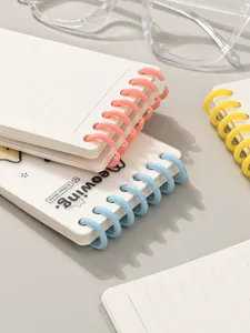 Mini cuaderno de hojas sueltas A7 con anillas de colores y papel rayado para notas.