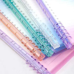Close-up detail van kleurrijke plastic ringbandringen en verloop notitieboek pagina's.