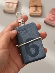 Close-up detail of mini leather notebook keychain with digital embossing, portable pocket diary.