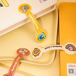 Detailopname van Betty's Dreams cartoon lederen notebookriemen op een crèmekleurig dienblad.