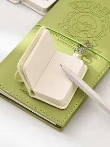 Mini pocket notebook set with green leather cover pen and star charm for daily journaling.