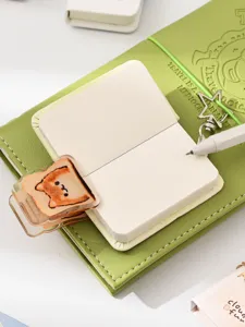 Detailed view of mini leather notebook set with cute toast cat clip, star charm and pen.