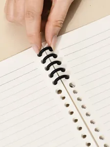 Afneembaar losbladig notitieboekje met gesegmenteerde zwarte ringen en gelinieerde pagina's.