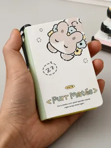 Close-up of a mini portable pocket notebook featuring a cute Purr Mates cartoon design.