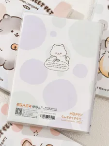 Detailopname van het schattige katten-notitieboekje met pvc-omslag en pastelkleurige stippen.