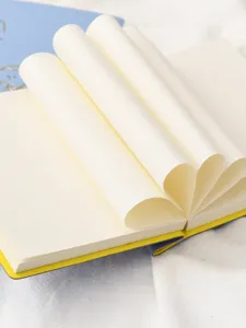 Primer plano detallado de plegado de papel creativo en un cuaderno de estudiante crema.