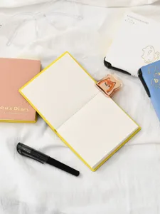 Bonito juego de papelería estética con cuadernos coloridos, bolígrafo negro y marcapáginas de gato.
