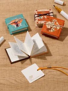 Detailed view of mini folding doodle sketchbooks set with cute cover designs and pens.
