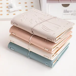 Stack of colorful leather travel journals with embossed cat and heart pattern details