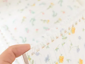 Close-up detail van zachte plastic spiraal en gelinieerde notebookpagina met bloemen.