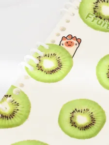 Cute kiwi fruit pattern detail shot of loose leaf notebook with spiral rings and cartoon paw.