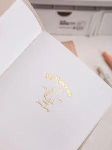 Detail view of gold foil cat motif on the leather travel itinerary journal page