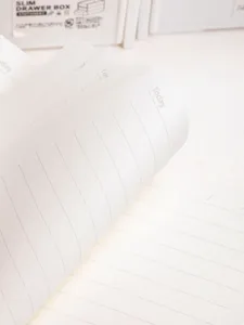 Close-up detail of lined notebook pages with a high-quality cream-colored paper texture.