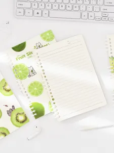 Detail view of A5 spiral notebook with cute green fruit and cat illustration, lined inner pages.