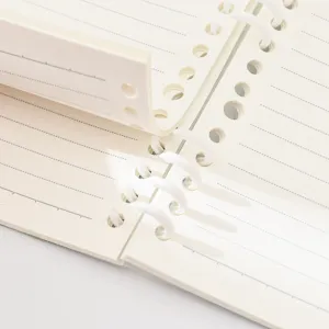 A5 loose leaf notebook with white segmented rings and lined cream pages for students.