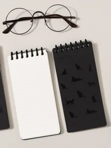 Close-up detail of pocket loose-leaf notebook with cute cat silhouettes and coil binding.