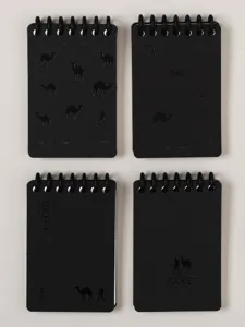 Primer plano de mini cuaderno de espiral negro con diseño de camello en relieve y texto.