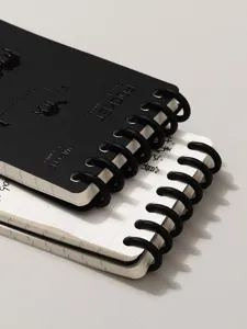 Cuaderno de notas de bolsillo portatil con anillas negras para notas diarias utiles.