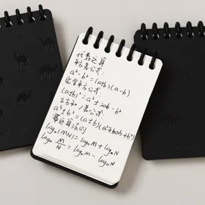 Cuaderno de espiral de bolsillo A7 con páginas rayadas, cubierta negra y diseño portátil.