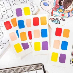 Watercolor paint swatch cards and coloring book details showing vibrant solid color blocks.