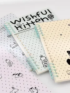 Détail de carnet à anneaux perforé mignon aux couvertures pastel et reliure spirale segmentée.