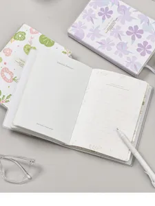 Vista detallada de páginas interiores del cuaderno con líneas, cubierta transparente y bolígrafo.