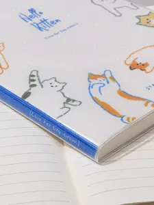 Gros plan d'un carnet chat mignon avec un dos bleu pailleté et des pages lignées.