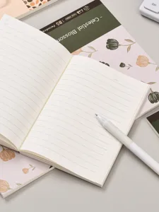 Gros plan détaillé d'un carnet ligné ouvert avec un stylo blanc sur fond propre.