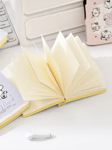 Schattig geel zaknotitieboekje detail met uitgevouwen crème pagina's op een wit bureau.