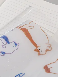 Gros plan détaillé d'un protège-cahier givré et pailleté avec dessin de chat.