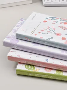 Primer plano detallado de un conjunto apilado de agendas florales y cuadernos bonitos.