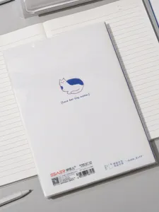 Gros plan sur le dos d'un carnet B5 avec une illustration minimaliste de chat