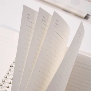 Close-up of minimalist spiral notebook inner pages with date and line number headers