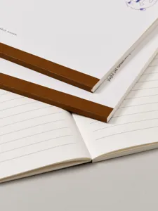 Elégant carnet ligné minimaliste avec dos en tissu marron et pages crème de qualité.