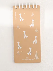 Gros plan détaillé d'un carnet à spirale en papier kraft marron avec de jolies girafes blanches.