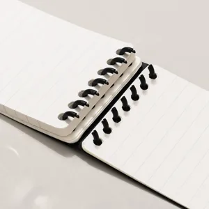 Portable pocket loose-leaf lined notebook with durable black spiral binding for daily writing.