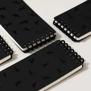 Black spiral notebook with cute cat silhouette pattern, portable pocket size for daily use.