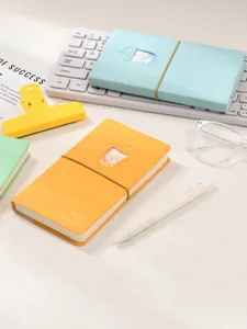 Vue détaillée de cahiers à thème bubble tea avec chat mignon sur un bureau blanc