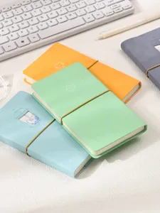 Gros plan de carnets de notes chat pastel avec bandes élastiques sur un bureau.