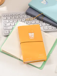 Gros plan d'un carnet jaune mignon sur le thème chat thé au lait avec sangle élastique