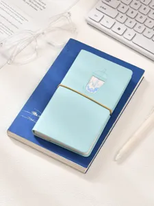 Détail d'un carnet chat thé au lait bleu clair avec bande élastique et motif