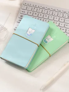 Vue détaillée de deux mignons agendas chat de thé au lait en bleu et vert menthe.