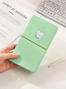 Gros plan d'un agenda chat bubble tea vert menthe avec bande élastique sur bureau