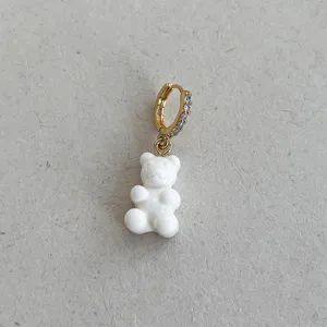 Dettaglio ravvicinato di un orecchino a cerchio con orsetto bianco e zirconi scintillanti