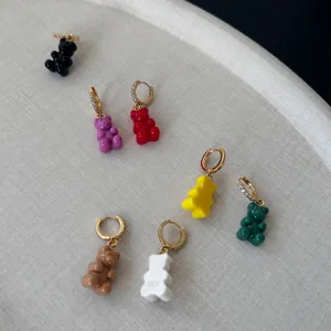 Dettaglio di orecchini a forma di orsetto in resina con cerchi lucidi in zirconia