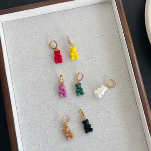 Dettaglio macro di orecchini colorati a forma di orsetto gommoso con cerchi in zirconia