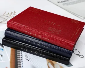 Gros plan detaille de carnets rigides vintage avec couverture texturee et texte dore.
