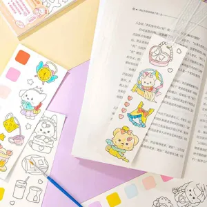Close-up detail of children watercolor coloring book, stickers and brush on pink desk.