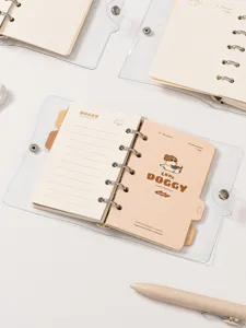 Vista dettagliata del quaderno ad anelli in PVC trasparente con motivi di cagnolini.